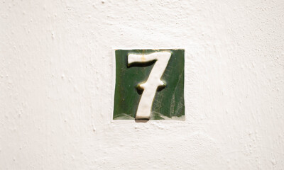 Decorative ceramic house number 7 tile on the wall, characteristic decorative element, number