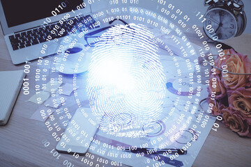 Computer on desktop in office with finger print drawing. Double exposure. Concept of business data security.