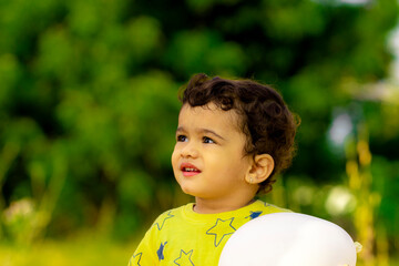 A beautiful little Indian child is happy with a white balloon in his hands