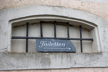 Old information sign on a public toilet