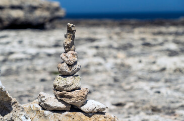 Pyramid of stones on the stone shore of the black sea . Crimea.