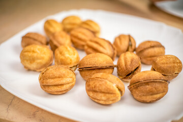 Lots of cookies Nuts with boiled condensed milk on a white plate close up