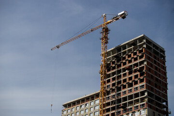 Crane and building construction site against blue sky
