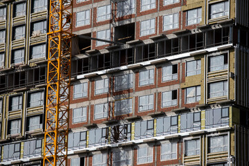 Preparing to pour a bucket of concrete into formwork.Tower crane lifting cement bucket during construction a multi-storey residential building. Construction cranes and builders in action