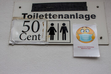 Sign toilet with the instruction to wear a mask