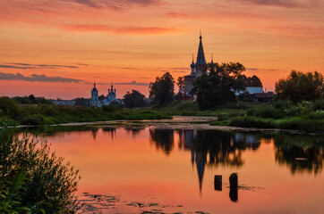 Fototapeta na wymiar Orthodox convent with beautiful sunset and reflections