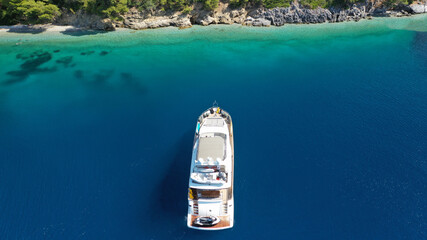 Aerial drone photo of yacht anchored in famous crystal clear bay and turquoise beach of Panormos,...