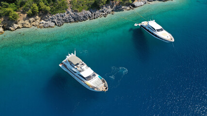 Aerial drone photo of yacht anchored in famous crystal clear bay and turquoise beach of Panormos, Skopelos island, Sporades, Greece