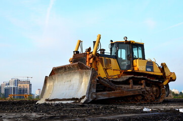 Bulldozer at construction site. Heavy equipment for digging, demolition, construction and ground works. Dozer for earth-moving, land clearing, grading, utility trenching and foundation digging