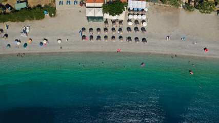 Fototapeta na wymiar Aerial top down photo of famous organised crystal clear turquoise sandy beach of Panormos, Skopelos isalnd, Sporades, Greece