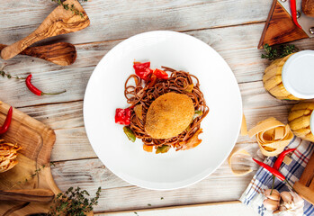 Fried kiev cutlet with soba noodles on white plate