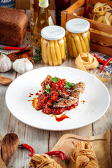 Fried fish fillet on vegetable saute in red sauce