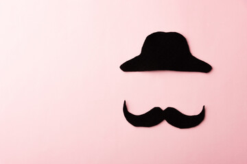 Black mustache and cap, studio shot isolated on pink background, Prostate cancer awareness month, Fathers day, minimal November moustache concept