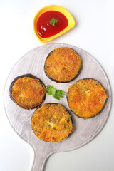 Indian side dish or appetizer  Vangyache Kaap, fried Eggplants, Crispy brinjal fry, Aubergine disks, served with tomato ketchup. With copy space