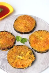 Indian side dish or appetizer  Vangyache Kaap, fried Eggplants, Crispy brinjal fry, Aubergine disks, served with tomato ketchup. With copy space