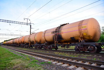 Fototapeta na wymiar Chemical Cars on railway. Petroleum rail. The rolling stock with petrochemical tank cars. Transportation methanol tank wagons. Out of focus, motion