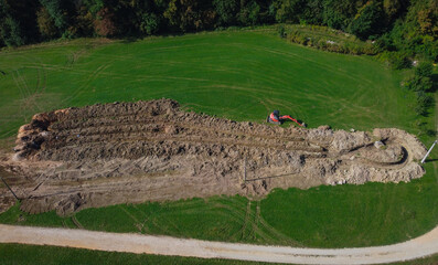 Aerial drone view of geothermal heating collector pit or trench in the ground. Excavation of ditch or holes for thermal heat exchanger for a house. Outside on a field.