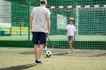 Man teaching his son how to play soccer