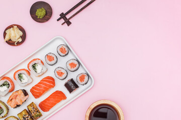 Sushi set with salmon on pink background, top view.