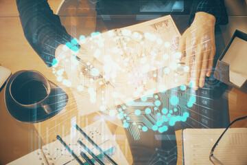 Multi exposure of woman's writing hand on background with brain hologram. Concept of brainstorming.