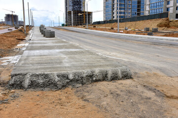 Road works activity at construction site. Construction and development projects on roads in city. Road concreting. Asphalt pavement is layered over concrete pavement