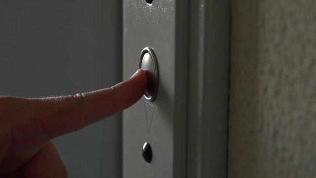 man presses the button to call the elevator. Close-up