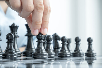 The hands of businesswomen moving chess in chess competitions demonstrate leadership, followers, and strategic plans, business success building processes, and teamwork