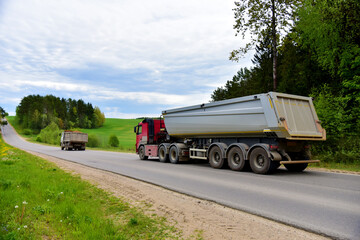Truck with tipper semi trailer transported sand from the quarry on driving along highway. Modern Dump Semi-Trailer Rear Tipper Truck Trailer