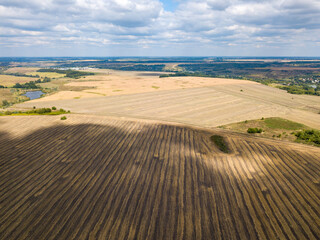 Aerial drone view. Harvested wheat field on a sunny day.