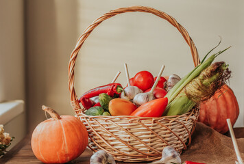 A wicker basket with ripe vegetables on a wooden table. Harvesting. Farm products.
