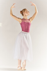 Fototapeta na wymiar woman ballerina in pointe shoes and in a tutu on a light background poses posing legs dance model