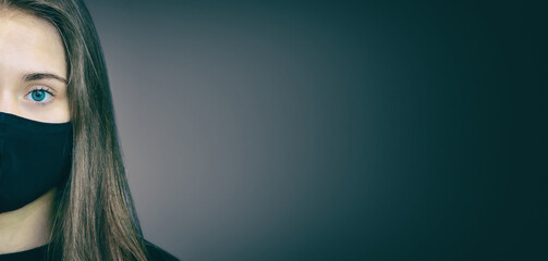 Portrait of a young girl in a black medical mask in a restrained way. The concept of protection...