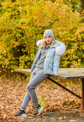 Fresh air and good mood. girl relax among fallen leaves. cosy sport suit. sporty girl with puffed jacket. wear comfort clothes. warm clothes for fall season. woman in hat enjoy autumn. walk in park