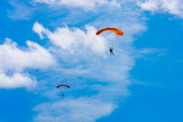 A parachutist against a background of blue sky and white clouds. Skydiving.
