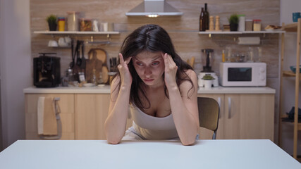 Depresed young woman having headache. Stressed tired unhappy ill worried unwell housewife suffering of migraine, depression, disease and anxiety feeling exhausted with dizziness symptoms