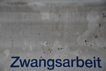 Aufschrift auf verwitterter Wand: "Zwangsarbeit"