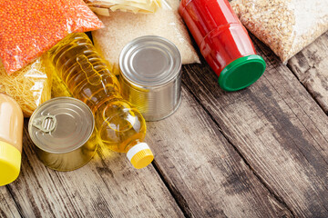 Donations food. Set of staple products raw cereals canned food, grocery pasta on wooden table. Donate help, delivery foodstuff during covid quarantine by volunteer community. charity