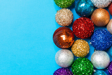 Festive composition of decorative baubles on colorful background. Top view of Christmas toys with copy space