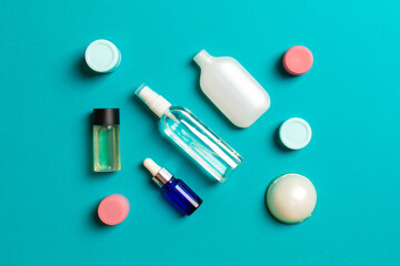 Cosmetics SPA branding mock-up, top view with copy space. set of tubes and jars of cream flat lay on colored background