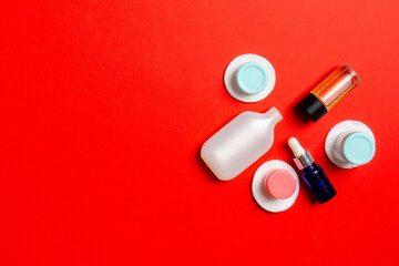 Set of travel size cosmetic bottles on colored background. Flat lay of cream jars. Top view of bodycare style concept