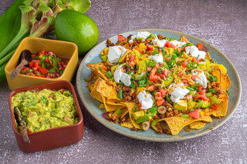 Loaded minced pork nachos with guacamole and salsa dips