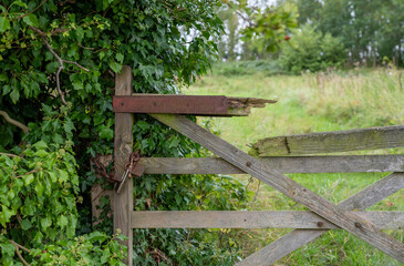 Brocken wooden gate with padlock