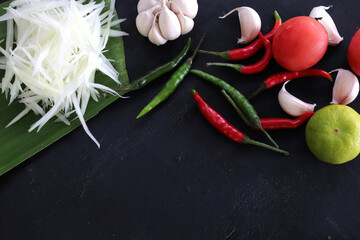Spices and vegetables for Papaya salad. Placed on black background. Top view. Free space for your text. Thai food concept.