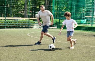 Sportive dad playing soccer with his son