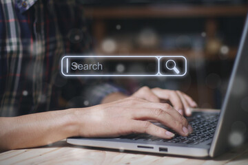 Search bar of internet browser and businessman working on modern laptop at table indoor with bokeh.