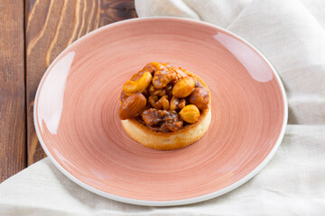 Tart with nuts on pink plate close up