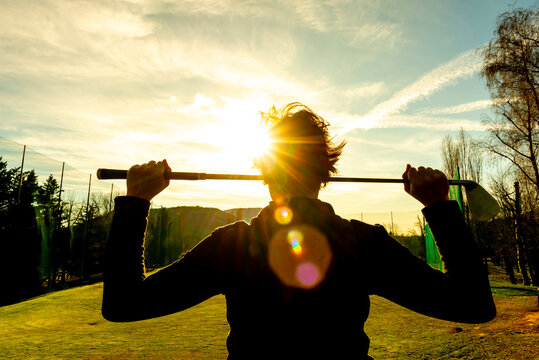 Golfer Leaning Her Golf Club on Her Shoulders with Sunlight.