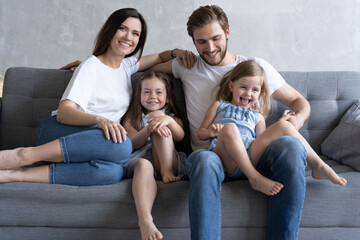 Cheerful family at home sitting in sofa