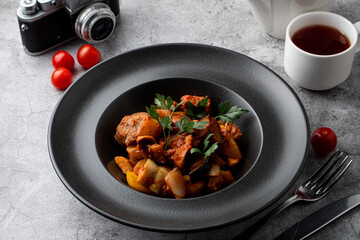 Traditional german veal ragout with big potato chunks on a grey background,?menu photography