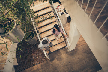 Top above high angle full length view photo of positive colleagues man woman go downstairs hold coffee cup have rest interesting talk enjoy company climate in workplace workstation - Powered by Adobe